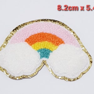 May include: A rainbow with clouds embroidered patch with a gold glitter border. The rainbow is pink, orange, yellow, green, and blue. The patch measures 8.2 cm by 5.4 cm.