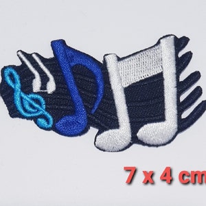 May include: An embroidered patch featuring musical notes and a treble clef in blue and white. The patch measures 7 cm by 4 cm.