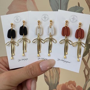 Kolczyki z gliny dyniowej, jesienne kolczyki z gliny, wiszące kolczyki z gliny, kolczyki z dyni, gliniane kolczyki z kokardkami, gliniane kolczyki na Halloween, kolczyki z gliny polimerowej