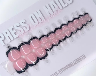 May include: Press-on nails with a black and white abstract design on a pink base. The nails are displayed on a white card with the text "PRESS ON NAILS" and "ETSY-BYCHARELLIZABETH".