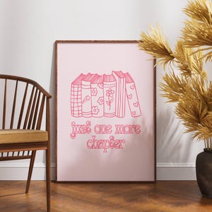 May include: Pink framed print with a stack of books and the text "just one more chapter" in a pink script font.