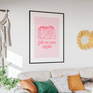 May include: A pink and white framed print with a stack of books and the text "just one more chapter" in pink.
