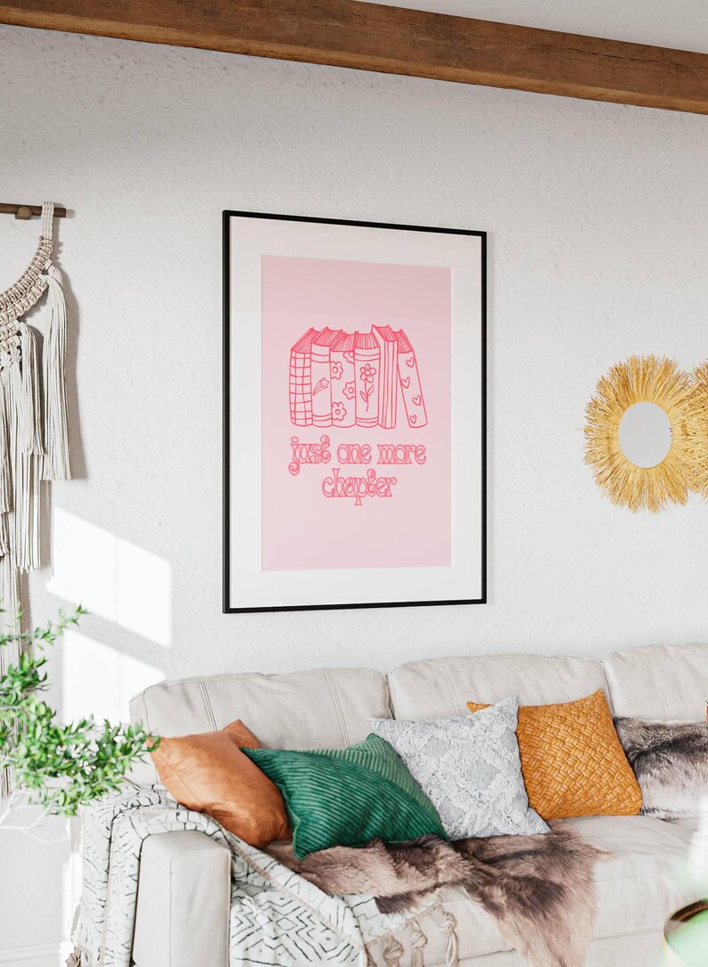 May include: A pink and white framed print with a stack of books and the text "just one more chapter" in pink.