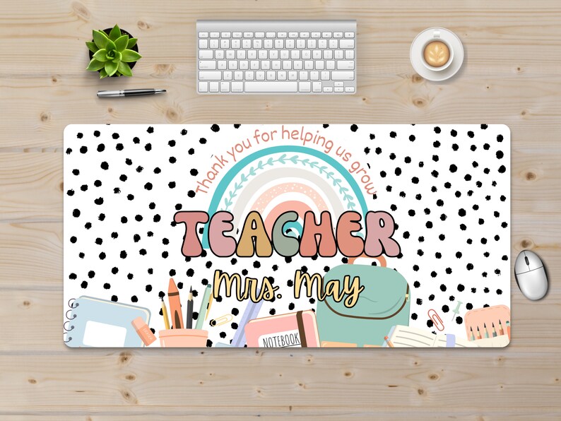 May include: White desk mat with black polka dots. It features a rainbow with the text "Thank you for helping us grow."  The word "TEACHER" is in colorful, bubble letters. The text "Mrs. May" is below the word "TEACHER".  There are school supplies on the bottom of the mat, including a pencil holder, a notebook, a backpack, and a binder.