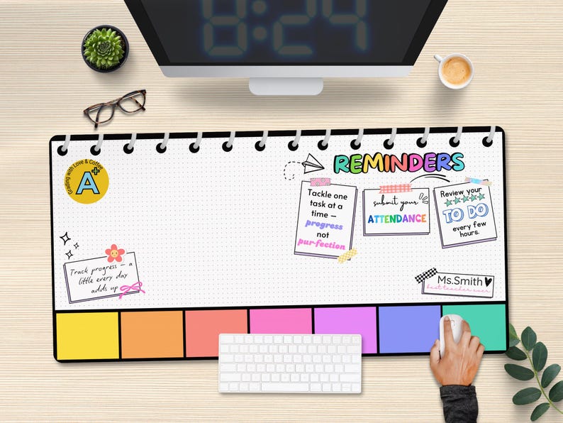 May include: A black and white desk mat with a colorful design. The mat has a grid pattern and includes the text "REMINDERS" with three colorful reminder boxes. The boxes include the text "Tackle one task at a time - progress not perfection", "Submit your attendance", and "Review your to do every few hours". The mat also includes a small sticker with the letter "A" and the text "Track progress - little every day adds up".