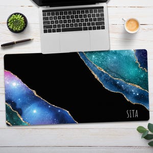 May include: A black and blue galaxy-themed mousepad with gold glitter accents and the word "Sita" in white text.