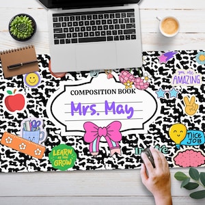 May include: Black and white composition book with a leopard print design. The book has a white label with the text "Composition Book" and "Mrs. May" in purple text. The book is decorated with colourful stickers, including a red apple, a pink bow, a light blue cup with pencils, a yellow smiley face, a purple brain, a light blue lightbulb with a smiley face, a pink star, a purple peace sign, and a white star with the text "You are amazing" in purple text.