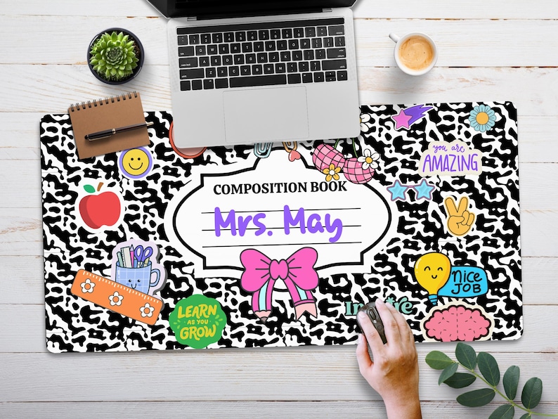 May include: Black and white composition book with a leopard print design. The book has a white label with the text "Composition Book" and "Mrs. May" in purple text. The book is decorated with colourful stickers, including a red apple, a pink bow, a light blue cup with pencils, a yellow smiley face, a purple brain, a light blue lightbulb with a smiley face, a pink star, a purple peace sign, and a white star with the text "You are amazing" in purple text.