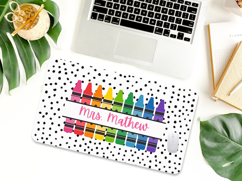 May include: A white mouse pad with black polka dots and a row of colorful crayons with the text "mrs. mathew" in pink.