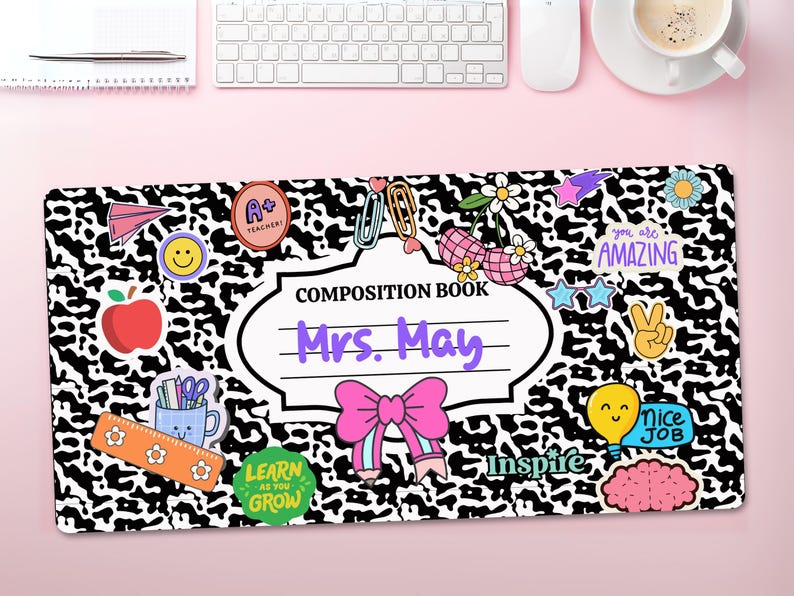 May include: Black and white composition book cover with a cow print pattern. The cover has a white label with the text "COMPOSITION BOOK" and "Mrs. May" in purple text. The cover is decorated with colourful stickers, including a red apple, a light blue pencil, a pink bow, and a yellow lightbulb.