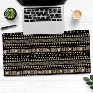 May include: Black and gold geometric patterned desk mat. The pattern features triangles, squares, and lines.