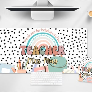 May include: A white and black polka dot desk mat with a rainbow and the text "Thank you for helping us grow" and "Teacher Mrs. May". The mat also includes a notebook, pencils, and a backpack.