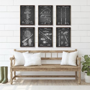 May include: Six black and white vintage fishing rod patent prints displayed on a white shiplap wall above a wooden bench with white cushions.