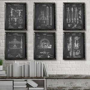 May include: Six black framed prints of vintage patent drawings for tools and measuring devices. The prints are hung on a white brick wall above a rustic wooden shelf with white books stacked on it.