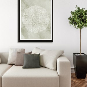 May include: A framed print of a white mandala design on a light green watercolor background.