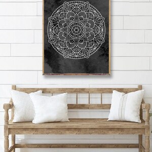 May include: A black and white mandala design on a dark gray background. The mandala is a circular pattern with intricate details and is framed in a wooden frame.