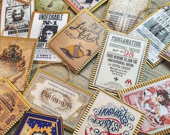 May include: A collection of decorative tags with gold frames and various designs. The tags feature text and illustrations from the Harry Potter series, including newspaper clippings, posters, and advertisements. Each tag has a string for hanging.