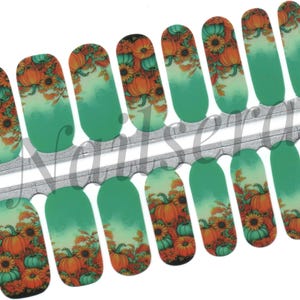 May include: Nail art strips with a seasonal autumn design. The strips display a pattern of orange pumpkins, sunflowers, and autumnal leaves against a teal and white gradient. The nail art is on a clear backing.