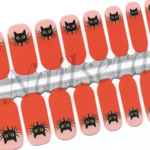 Op de afbeelding: Een set nagellakstrips met een feloranje basiskleur die vervaagt naar lichtroze bij de afgeronde uiteinden. Elke strip is versierd met een zwarte afbeelding van een kattengezicht met grote gele ogen en snorharen, gerangschikt in twee rijen.