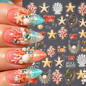 Könnte beinhalten: Ein Bogen mit Nagelaufklebern mit ozeanischen Motiven wie Seesternen, Korallen, Muscheln und Krabben. Die Aufkleber sind in Rosa, Weiß und Gold gehalten. Der Text FULL BEAUTY ist in einem kleinen rechteckigen Feld aufgedruckt.