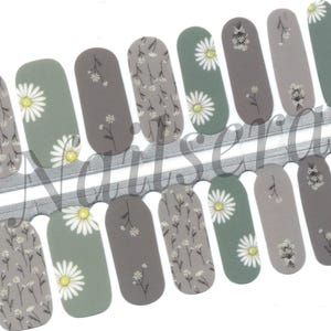 May include: Nail art strips featuring a variety of designs. Some strips have a daisy pattern with white petals and yellow centers, while others have a floral pattern with small white flowers on a gray background. The strips are in shades of gray and green.