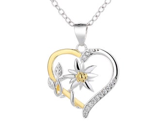 May include: A silver and gold heart-shaped pendant necklace with a white edelweiss flower and leaves. The pendant is adorned with clear cubic zirconia stones.