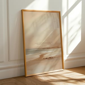 Op de afbeelding: Een ingelijste kunstdruk met een strandscène in gedempte tinten beige, blauw en bruin. Het kunstwerk bevat de tekst "Vertrouw uw werken aan de Heer toe, en uw plannen zullen slagen" uit Spreuken 16:3.