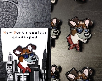May include: A set of enamel pins featuring a cartoon dog wearing sunglasses and a red bandana. The pins are in various poses and have a city skyline background. The text "New York's coolest quadarped" is on the pin.