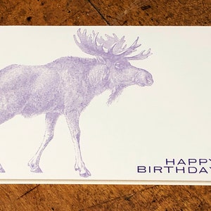 May include: A purple moose illustration on a white card with the text "HAPPY BIRTHDAY" in purple.