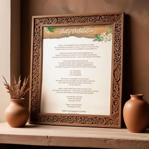 May include: A framed print with the text "Daily Declaration" in an ornate wooden frame. The print features a script with inspirational text and floral accents. Two terracotta vases are on the left and right.