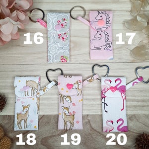 May include: Fabric keyrings with diverse patterns: floral, unicorns, deer, and flamingos. Each keyring features a metal ring and a fabric loop. Numbers 16, 17, 18, 19, and 20 are printed on the image.