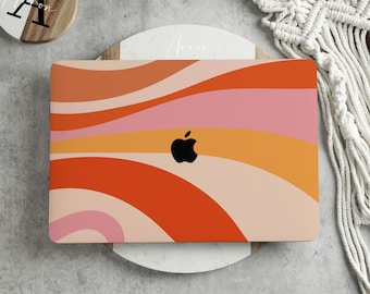 May include: A laptop computer with a colourful abstract design on the cover. The design features wavy lines in shades of orange, pink, and yellow. The Apple logo is visible in the centre of the cover.
