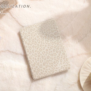 May include: A beige notebook with a leopard print design. The notebook is lying on a white fluffy surface. The text "#PERSONALIZATION." is visible in the top left corner of the image.