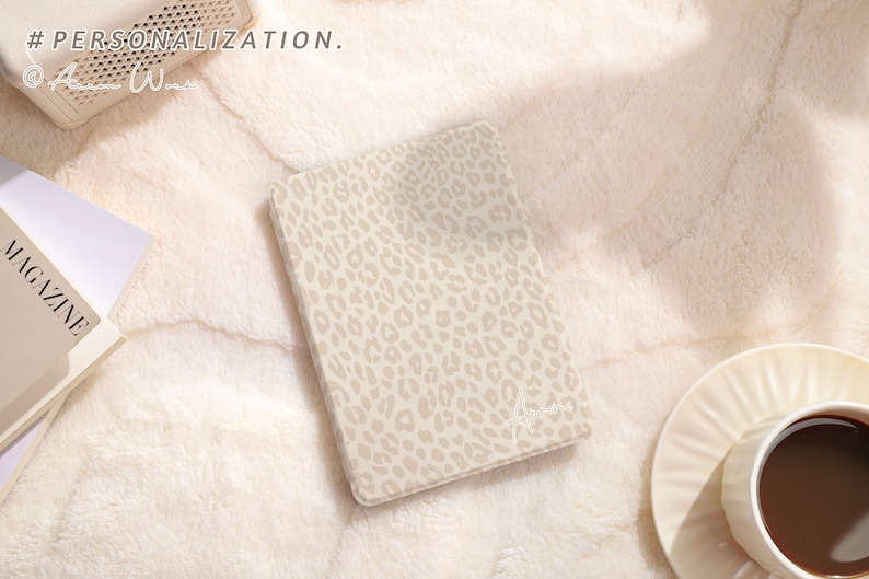 May include: A beige notebook with a leopard print design. The notebook is lying on a white fluffy surface. The text "#PERSONALIZATION." is visible in the top left corner of the image.