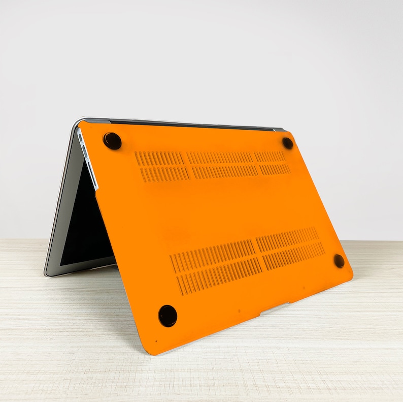 May include: Orange laptop case with a textured design and black rubber feet. The case is open and the laptop is visible inside.