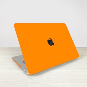 May include: Orange laptop computer with an Apple logo on the lid.