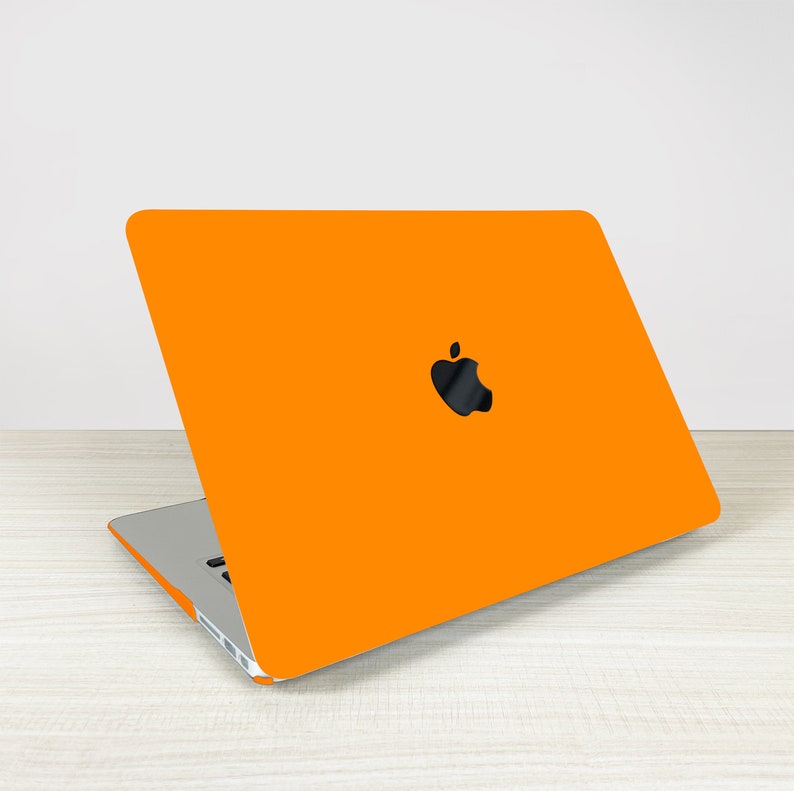 May include: Orange laptop computer with an Apple logo on the lid.