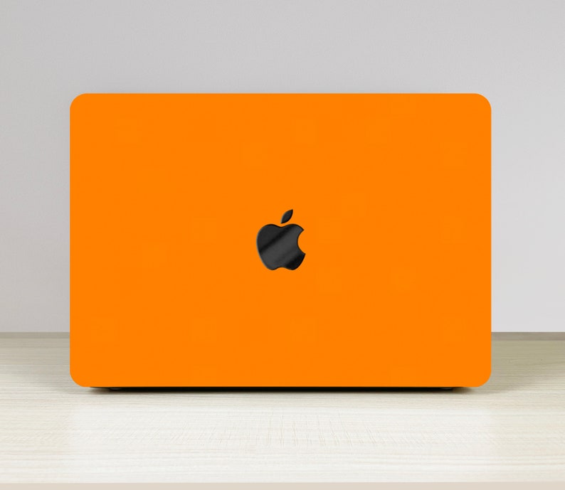 May include: A bright orange laptop with a black Apple logo on the lid.