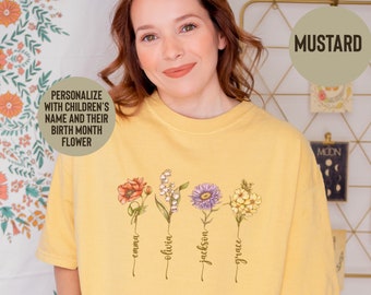 May include: Mustard-colored t-shirt featuring four floral illustrations with names below each flower. The text "PERSONALIZE WITH CHILDREN'S NAME AND THEIR BIRTH MONTH FLOWER" is displayed on the left. The word "MUSTARD" is in a circle on the right.