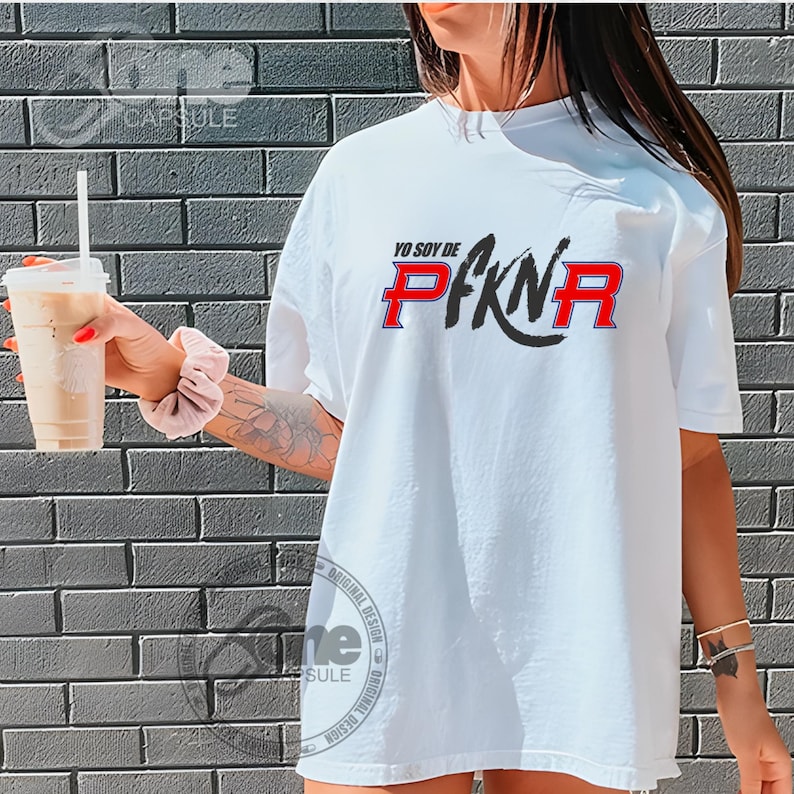 May include: White t-shirt with a black and red graphic that says "Yo soy de PFKN" in Spanish.