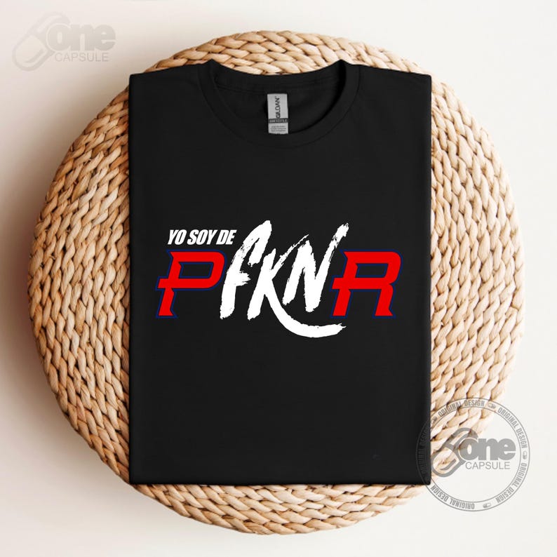 May include: Black t-shirt with white text that says "Yo soy de" and "PFKN" in red and blue letters.