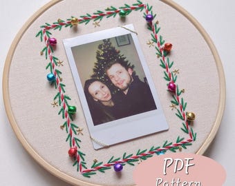 May include: An embroidered hoop featuring a photograph of a couple. The photo is framed by a square of green and red stitching with small gold stars and colorful bells. The text "PDF Pattern" is visible.