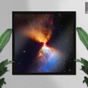 Puede incluir: Una impresión enmarcada de una nebulosa colorida en el espacio. La nebulosa es de color naranja y rojo brillante en el centro, con tonos azules y morados que se extienden hacia afuera. El fondo es azul oscuro con estrellas dispersas.