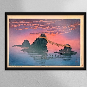 Puede incluir: Una estampa japonesa en madera que representa una puerta torii tradicional en una isla rocosa en el mar. El cielo es de un rosa y naranja vibrantes, con nubes que se reflejan en el agua. La estampa está enmarcada en negro.