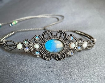 May include: A black macrame necklace featuring a blue labradorite gemstone and white pearl accents.