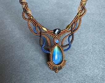 May include: A blue and brown macrame necklace with a teardrop-shaped iridescent gemstone pendant.