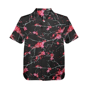 May include: Black short-sleeved button-up shirt with a floral pattern. The shirt features a repeating design of pink cherry blossoms and branches against a black background. The shirt has a classic collar and button-down front.