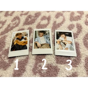 May include: Three white polaroid-style photos with images of a person. The photos are numbered 1, 2, and 3. The background is a patterned rug in shades of purple and white.