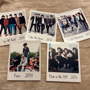 Może przedstawiać: Pięć wydruków w stylu polaroid z zespołem chłopięcym. Każdy wydruk przedstawia inne zdjęcie grupowe z tytułami albumów "Up All Night", "Take Me Home", "Midnight Memories", "Four" i "Made in the A.M." oraz ich odpowiednimi latami.