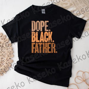 May include: Black t-shirt with the words "DOPE. BLACK. FATHER." in a gradient orange font. The shirt is made of a soft material and is likely a casual wear item. The text is centered on the front of the shirt.